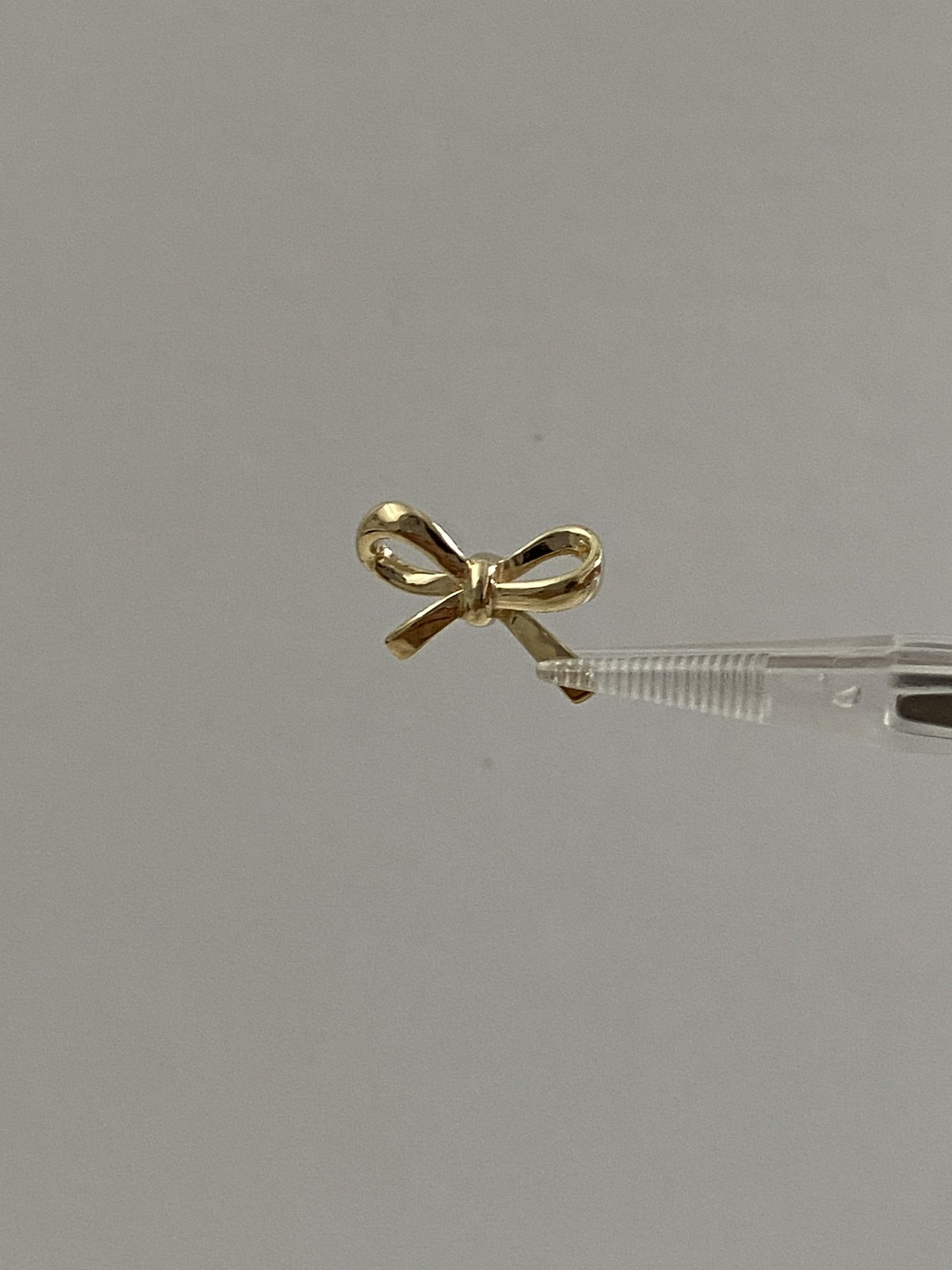 Actual product photo of 14K Solid Gold Ribbon Bow Pendant, reference view 1