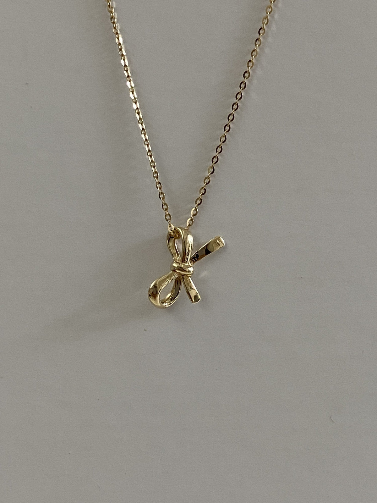 Actual product photo of 14K Solid Gold Ribbon Bow Pendant, reference view 2