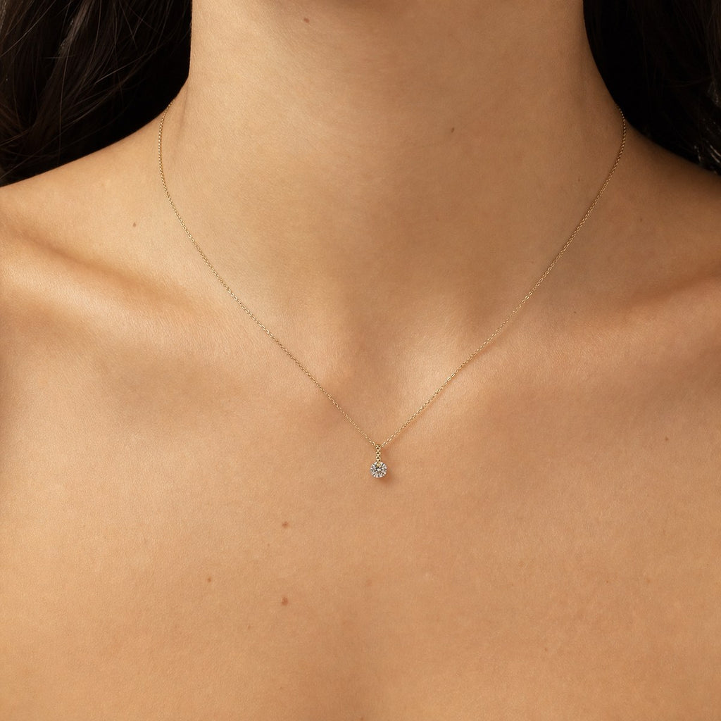 14K solid gold solitaire drop pendant worn on a fine chain