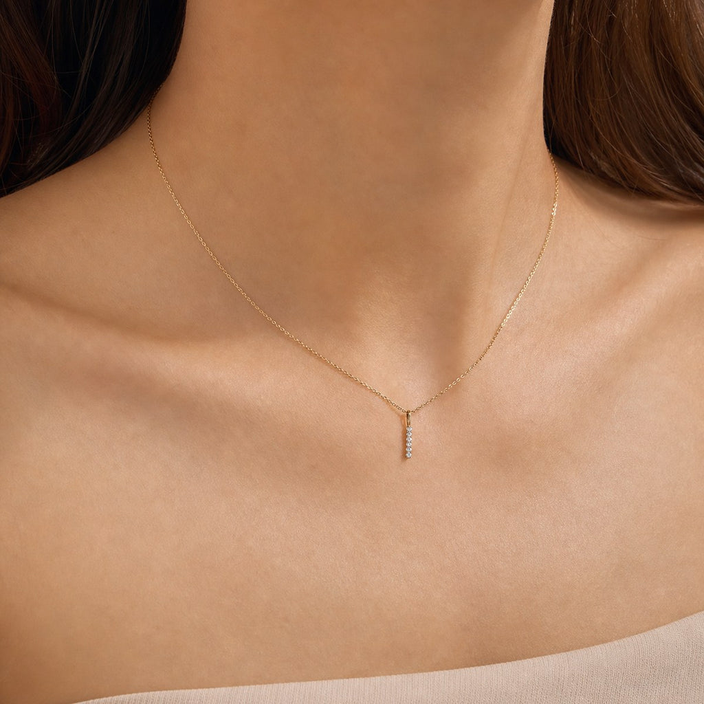 14K solid gold pavé bar pendant worn on a fine chain