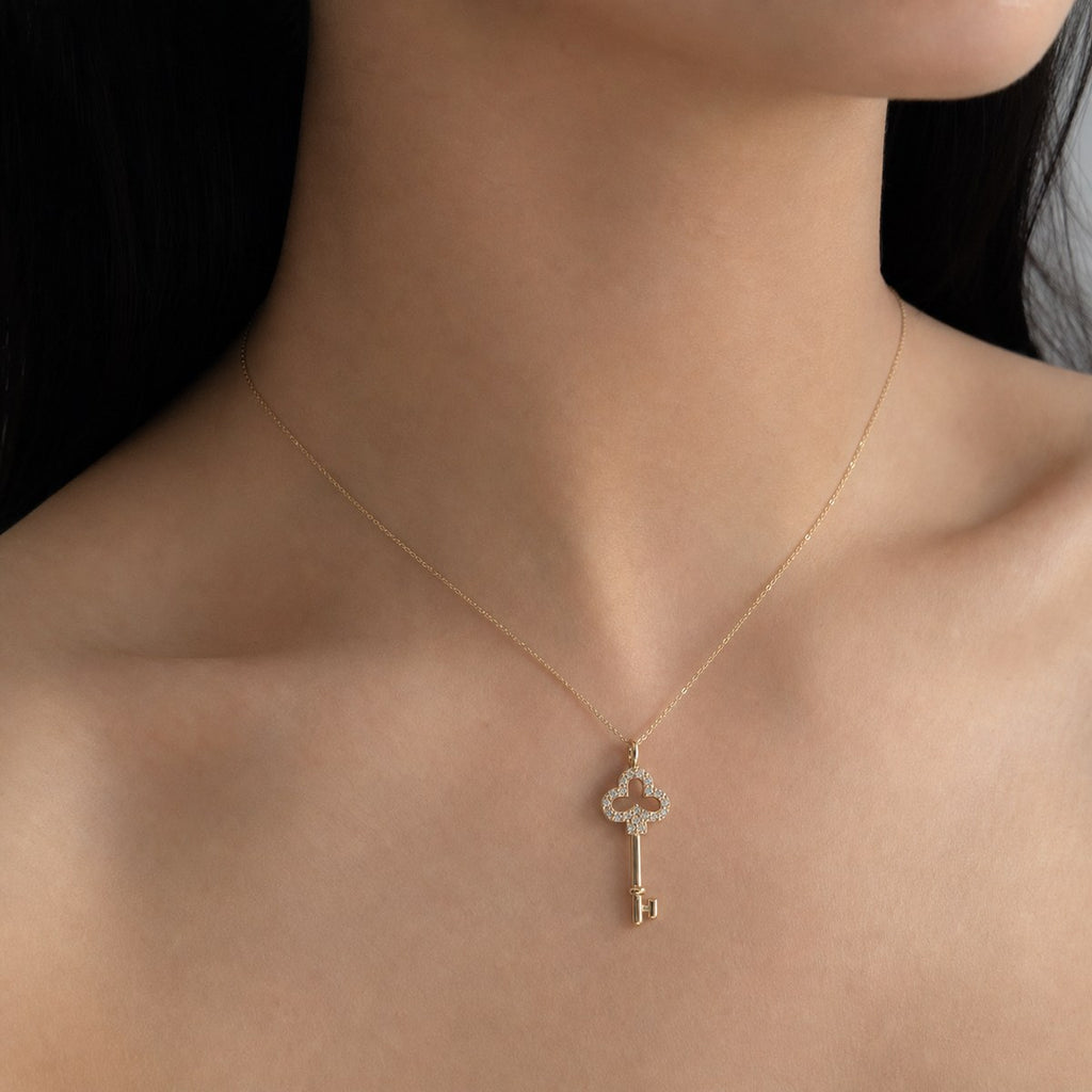 14K solid gold pavé clover key pendant worn on a fine chain