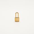 14K solid gold padlock pendant on a warm ivory background
