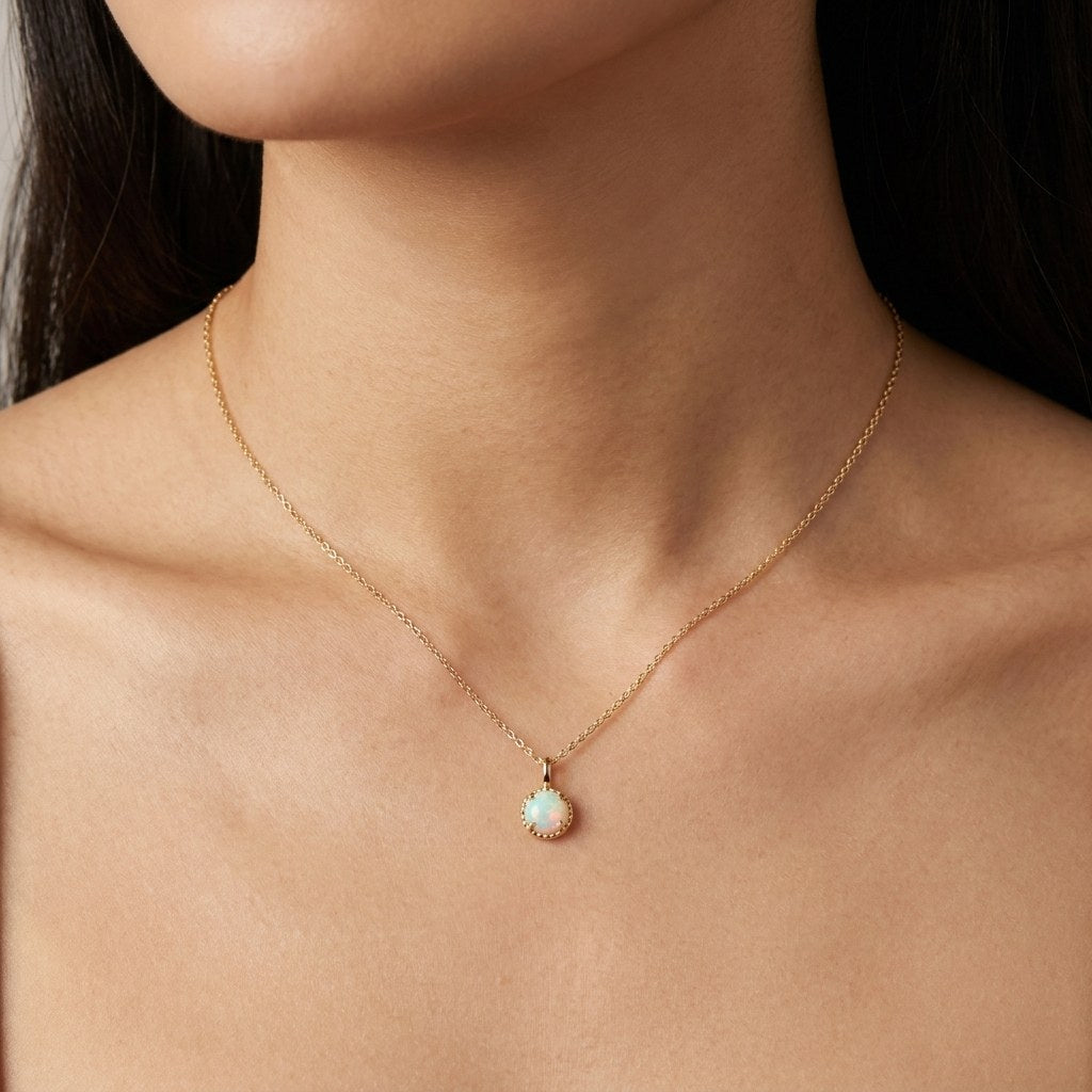14K solid gold opalescent round halo pendant worn on a fine chain