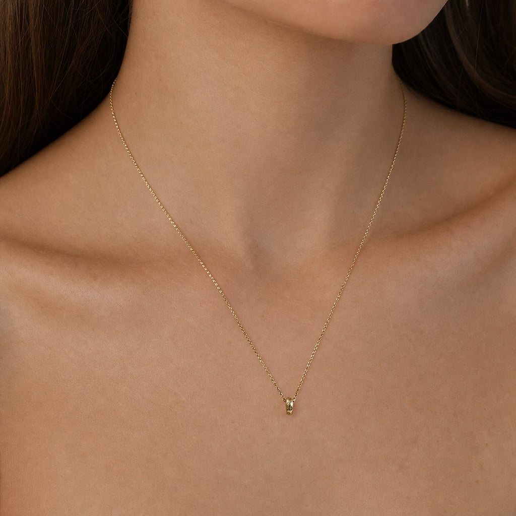 14K solid gold moissanite oval ring pendant worn on a fine chain