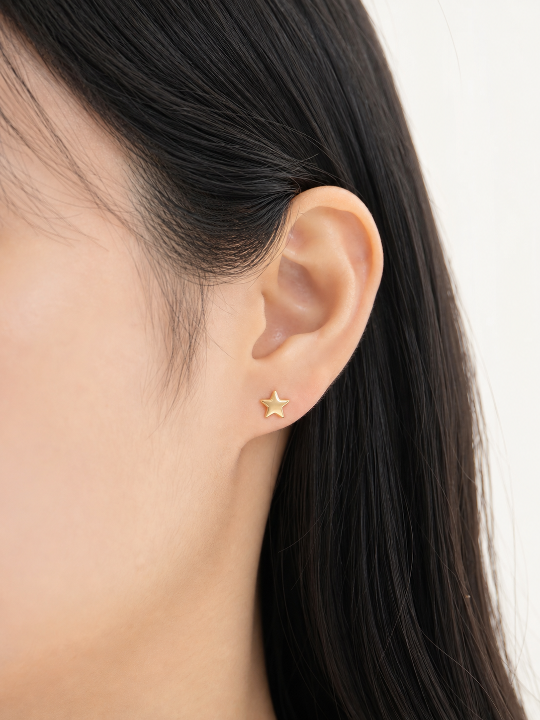 Solid gold five-point star stud earring worn on ear, product 401