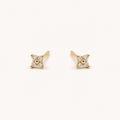 14K solid gold crystal floral star stud earrings on a warm ivory background