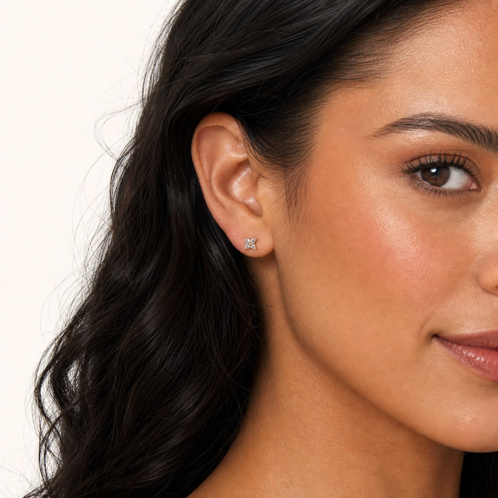 14K solid gold crystal floral star stud earrings worn on an ear