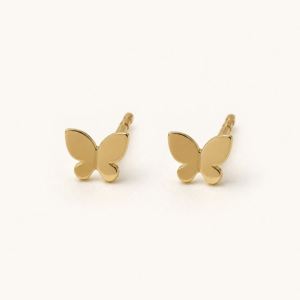 14K solid gold polished butterfly stud earrings on a warm ivory background