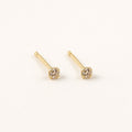 14K solid gold petite bezel solitaire stud earrings on a warm ivory background