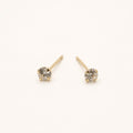 14K solid gold petite round solitaire stud earrings on a warm ivory background