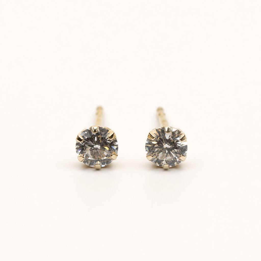 14K solid gold classic round solitaire stud earrings on a warm ivory background
