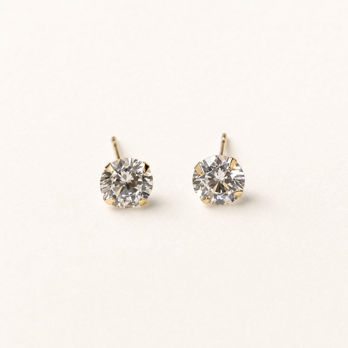 14K solid gold large round solitaire stud earrings on a warm ivory background