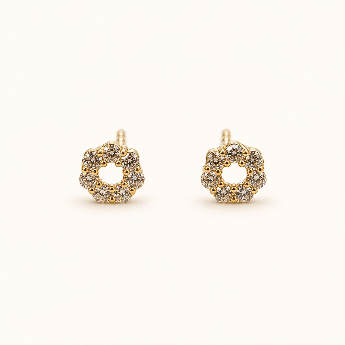 14K solid gold floral halo stud earrings on a warm ivory background