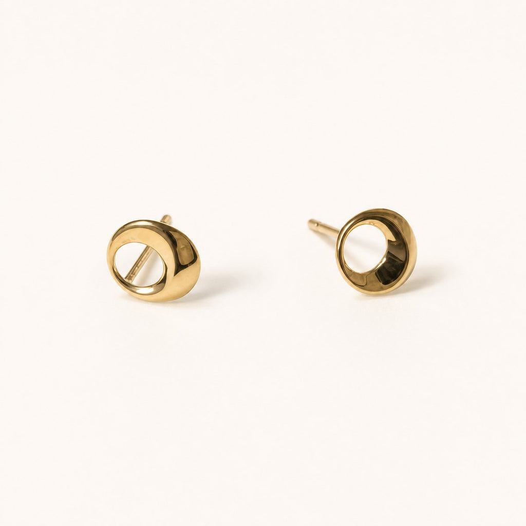 14K solid gold open circle stud earrings on a warm ivory background