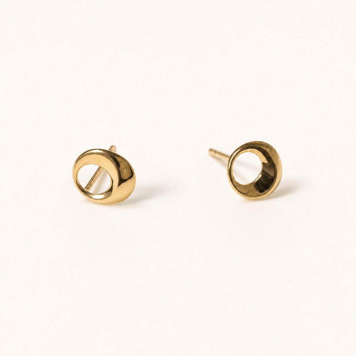 14K solid gold open circle stud earrings on a warm ivory background