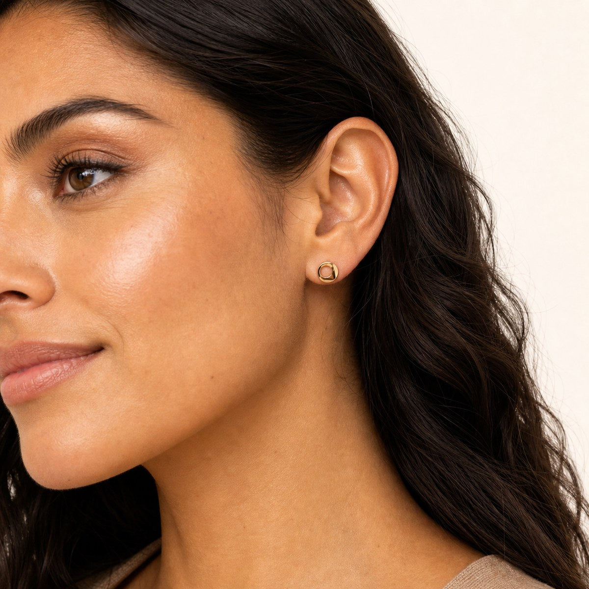 14K solid gold open circle stud earrings worn on an ear