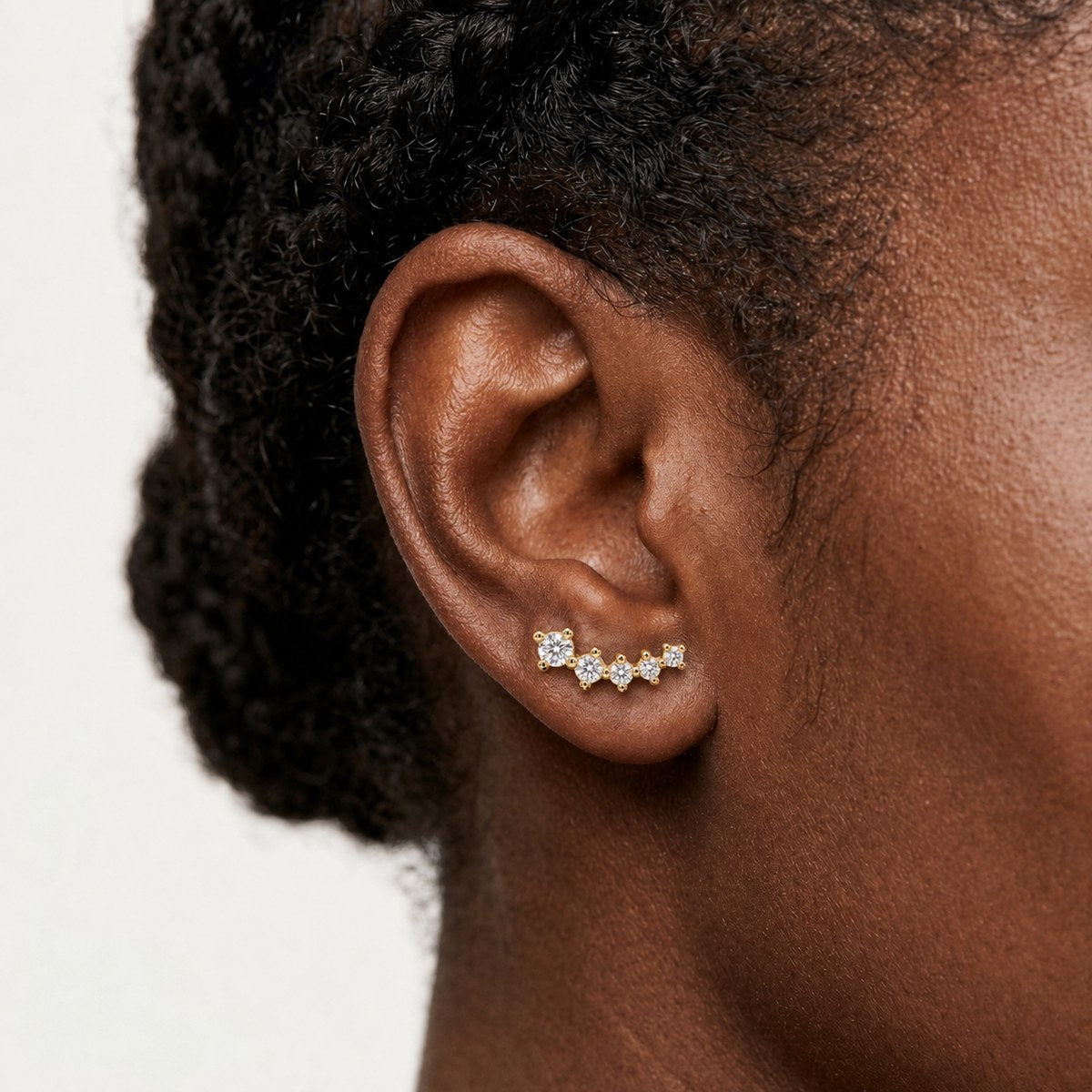 14K solid gold crystal tiara stud earrings worn on an ear
