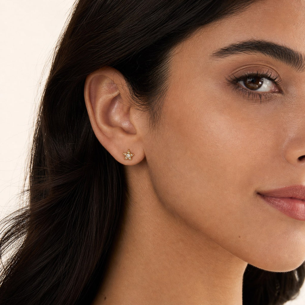 14K solid gold star cluster stud earrings worn on an ear