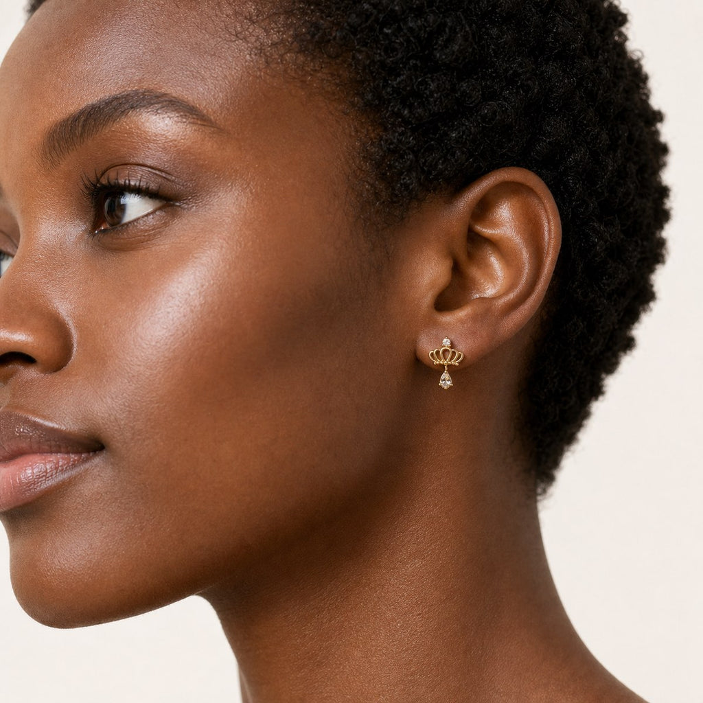 14K solid gold ornate teardrop drop stud earrings worn on an ear