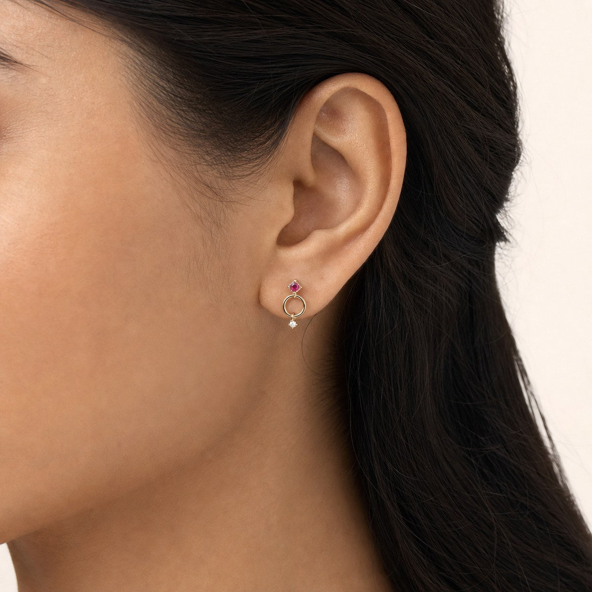 14K solid gold geometric circle drop stud earrings worn on an ear