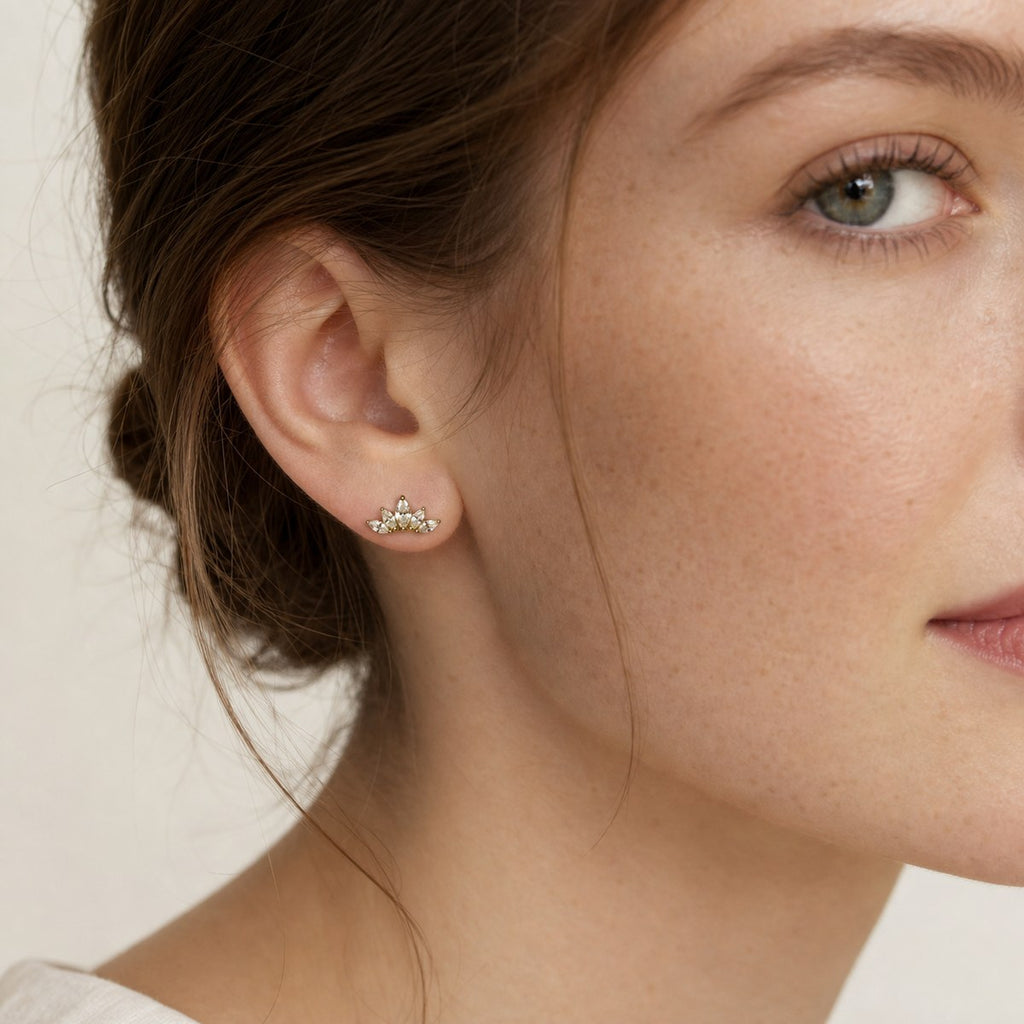 14K solid gold crystal lotus stud earrings worn on an ear