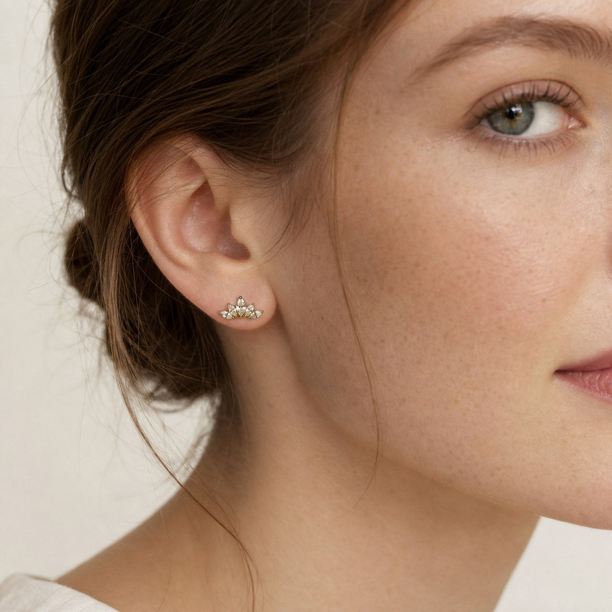 14K solid gold crystal lotus stud earrings worn on an ear
