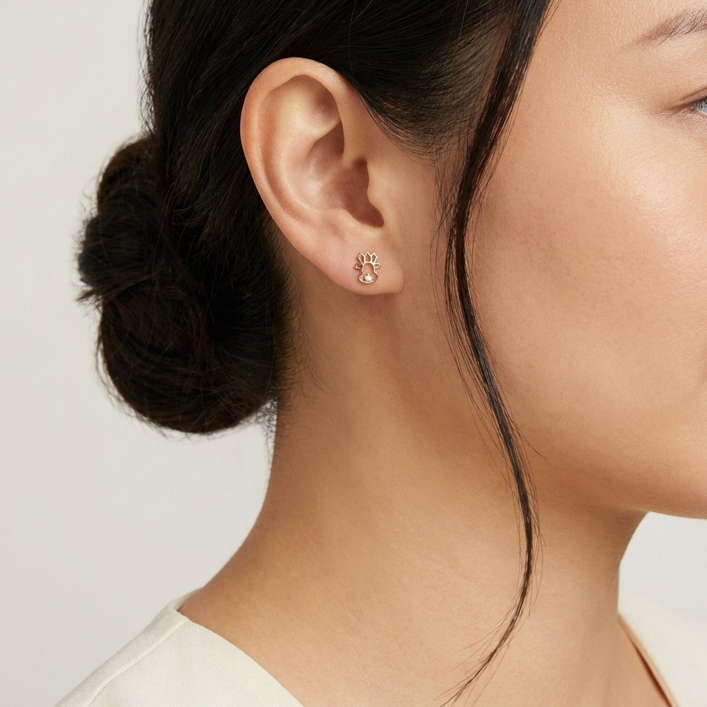 14K solid gold sun cloud stud earrings worn on an ear
