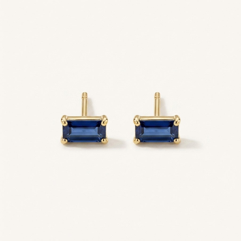 14K solid gold blue emerald cut stud earrings on a warm ivory background