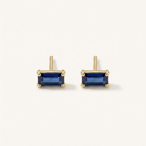 14K solid gold blue emerald cut stud earrings on a warm ivory background