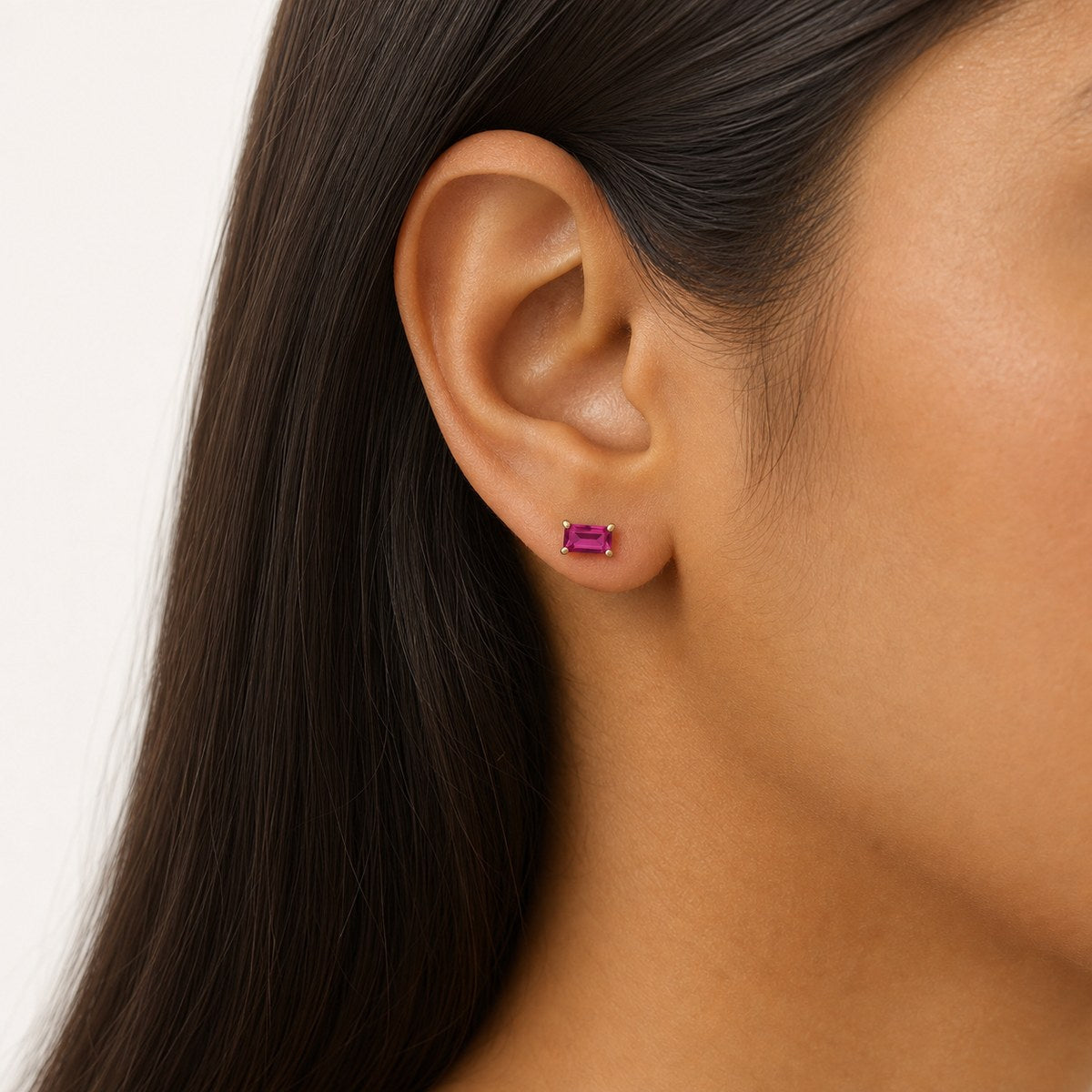 14K solid gold pink baguette stud earrings worn on an ear