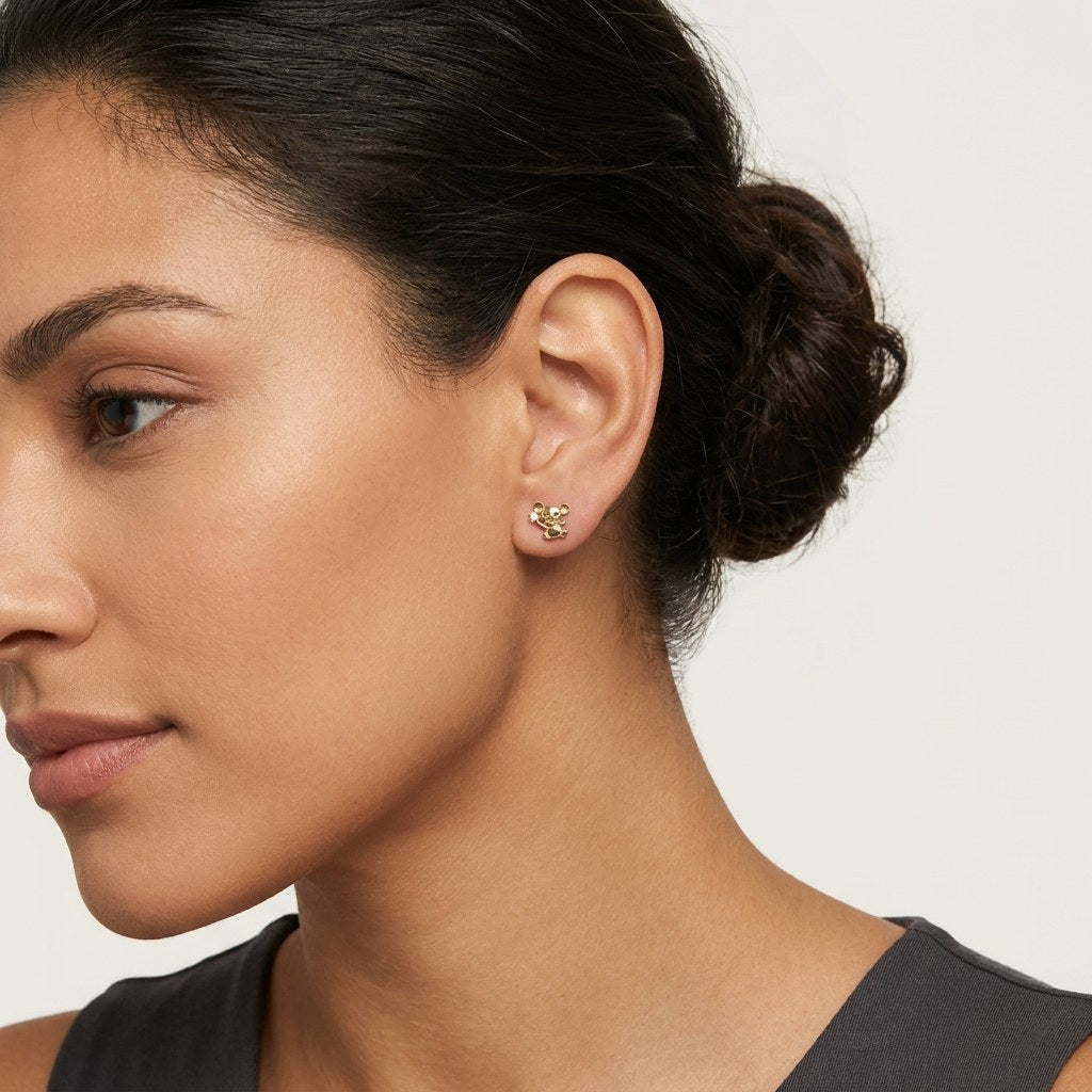 14K solid gold playful teddy stud earrings worn on an ear