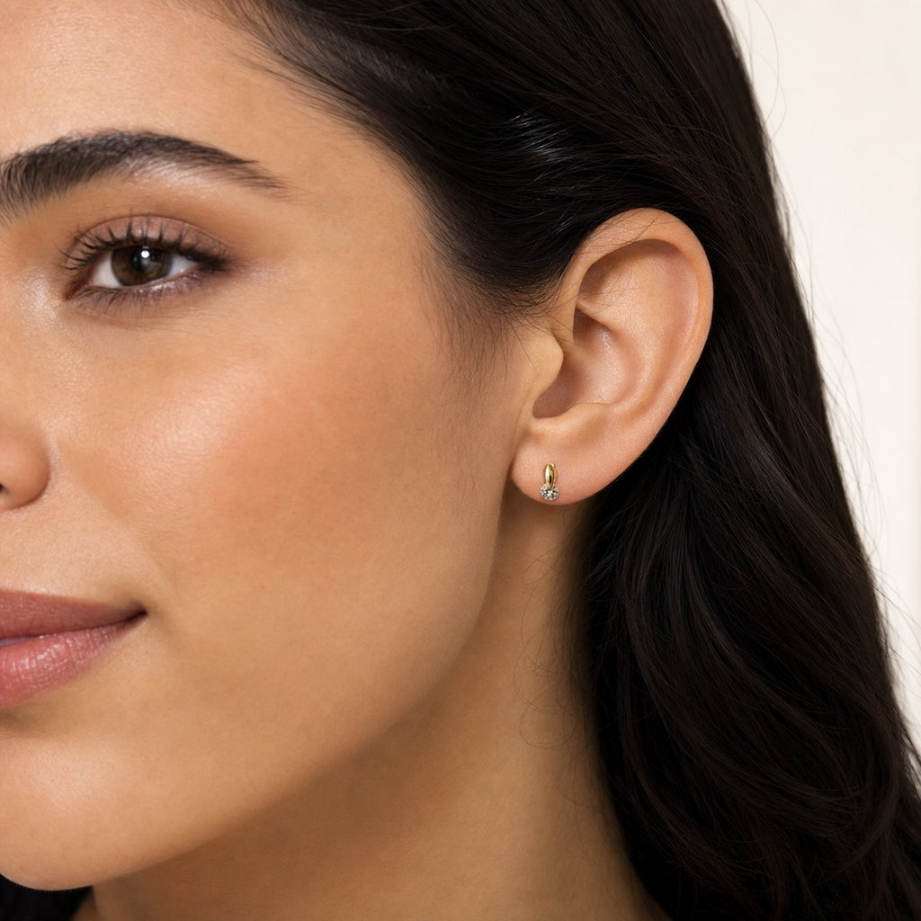 14K solid gold teardrop solitaire drop stud earrings worn on an ear