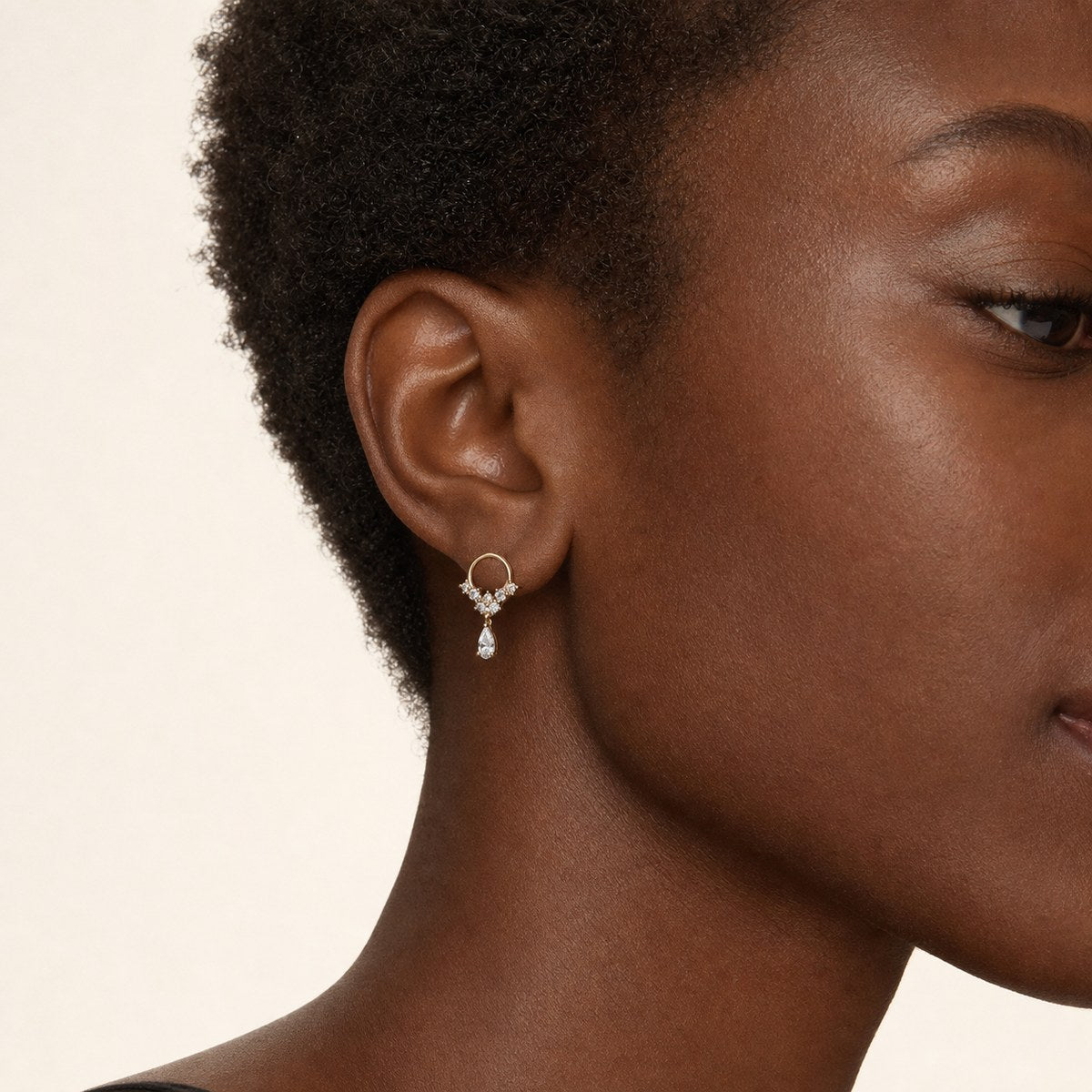 14K solid gold floral teardrop drop stud earrings worn on an ear
