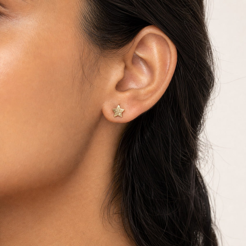 14K solid gold moon star stud earrings worn on an ear