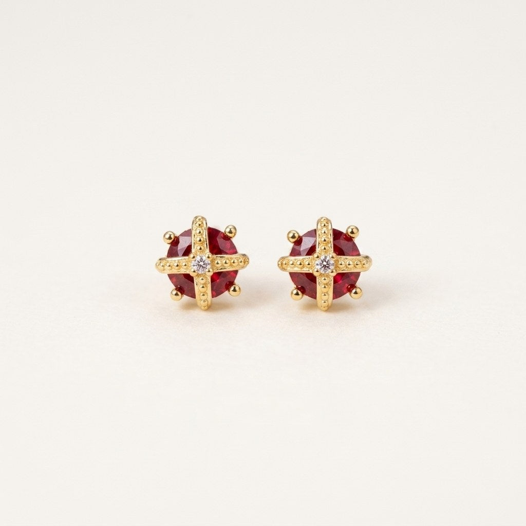 14K solid gold ruby cross stud earrings on a warm ivory background