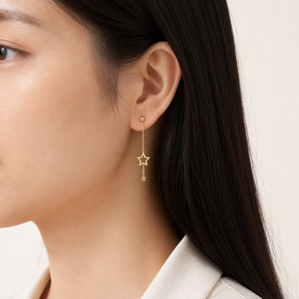 14K solid gold double star stud earrings worn on an ear