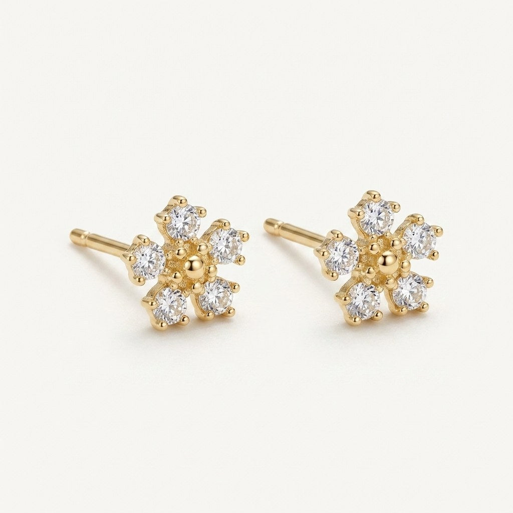 14K solid gold crystal daisy stud earrings on a warm ivory background