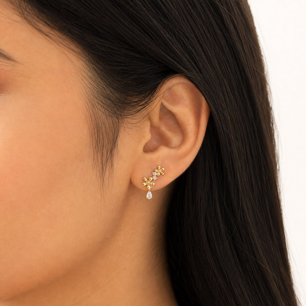 14K solid gold flower branch drop stud earrings worn on an ear