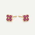 14K solid gold ruby clover stud earrings on a warm ivory background