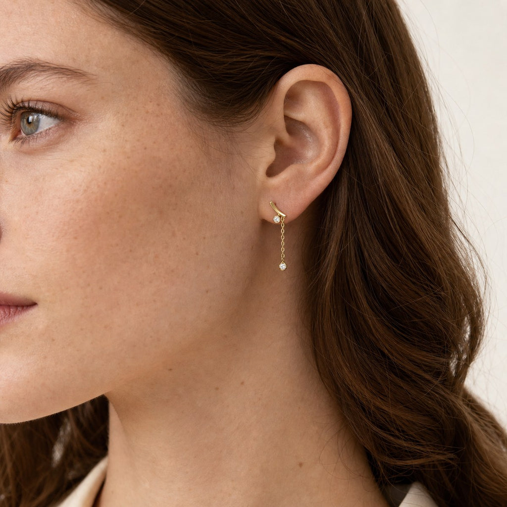 14K solid gold curved bar chain drop earrings worn on an ear