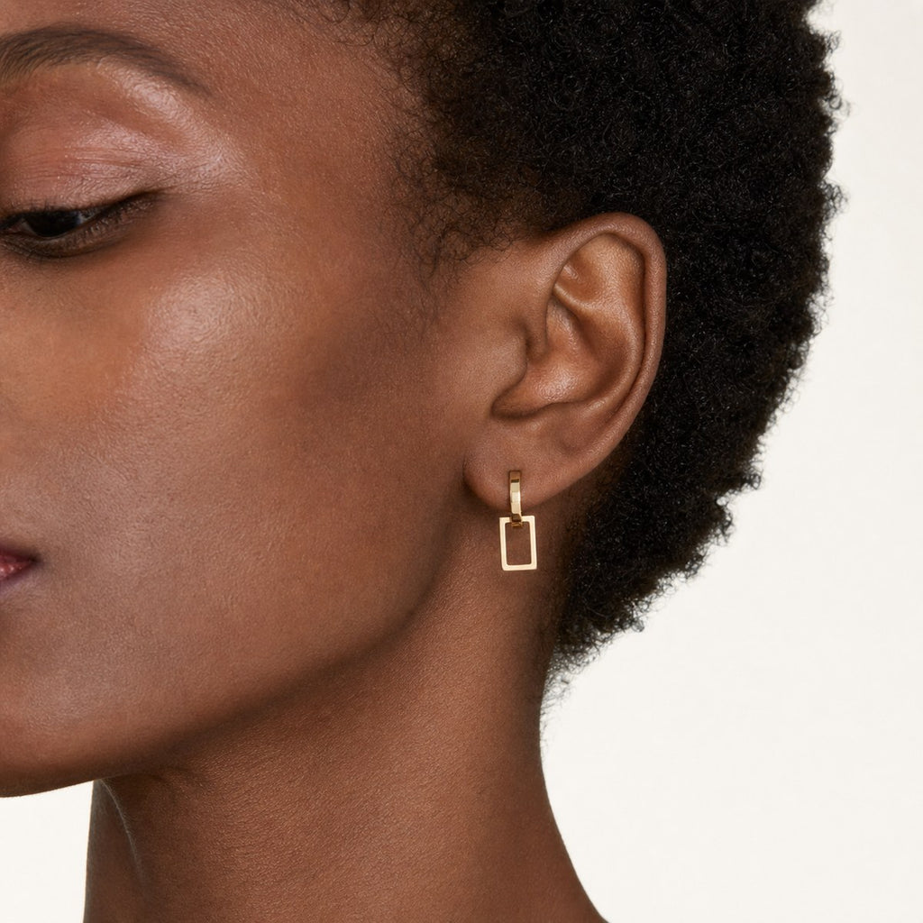 14K solid gold geometric rectangle drop stud earrings worn on an ear