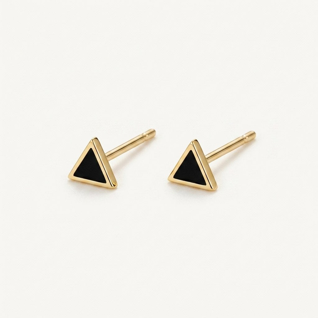 14K solid gold black triangle stud earrings on a warm ivory background