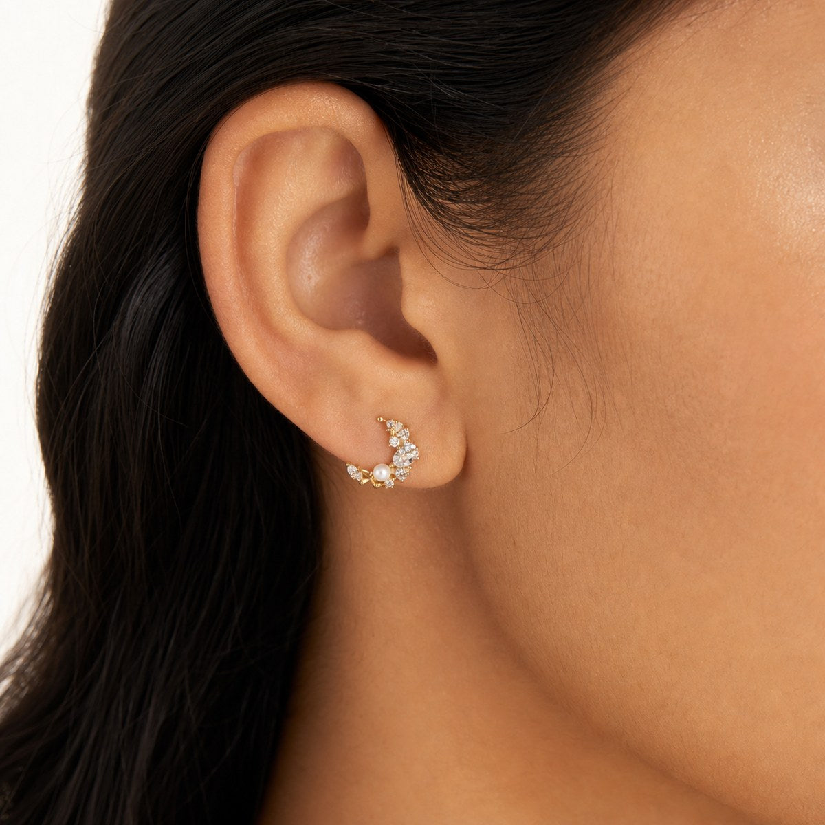 14K solid gold pearl crescent cluster stud earrings worn on an ear
