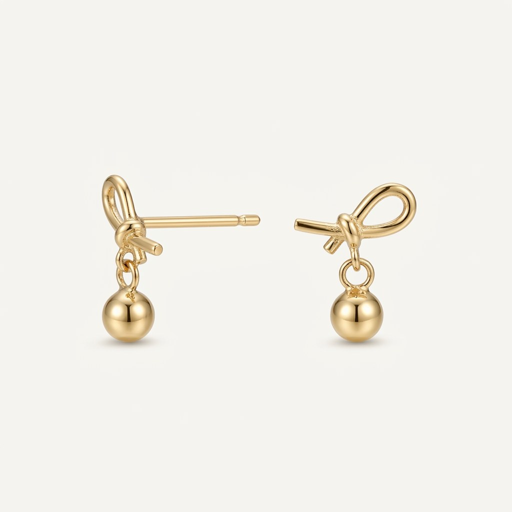 14K solid gold bow ball drop stud earrings on a warm ivory background