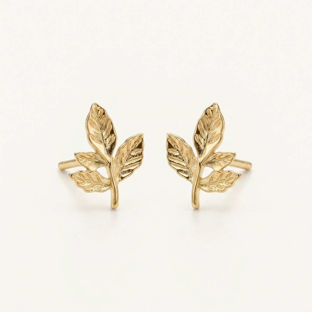 14K solid gold textured leaf branch stud earrings on a warm ivory background