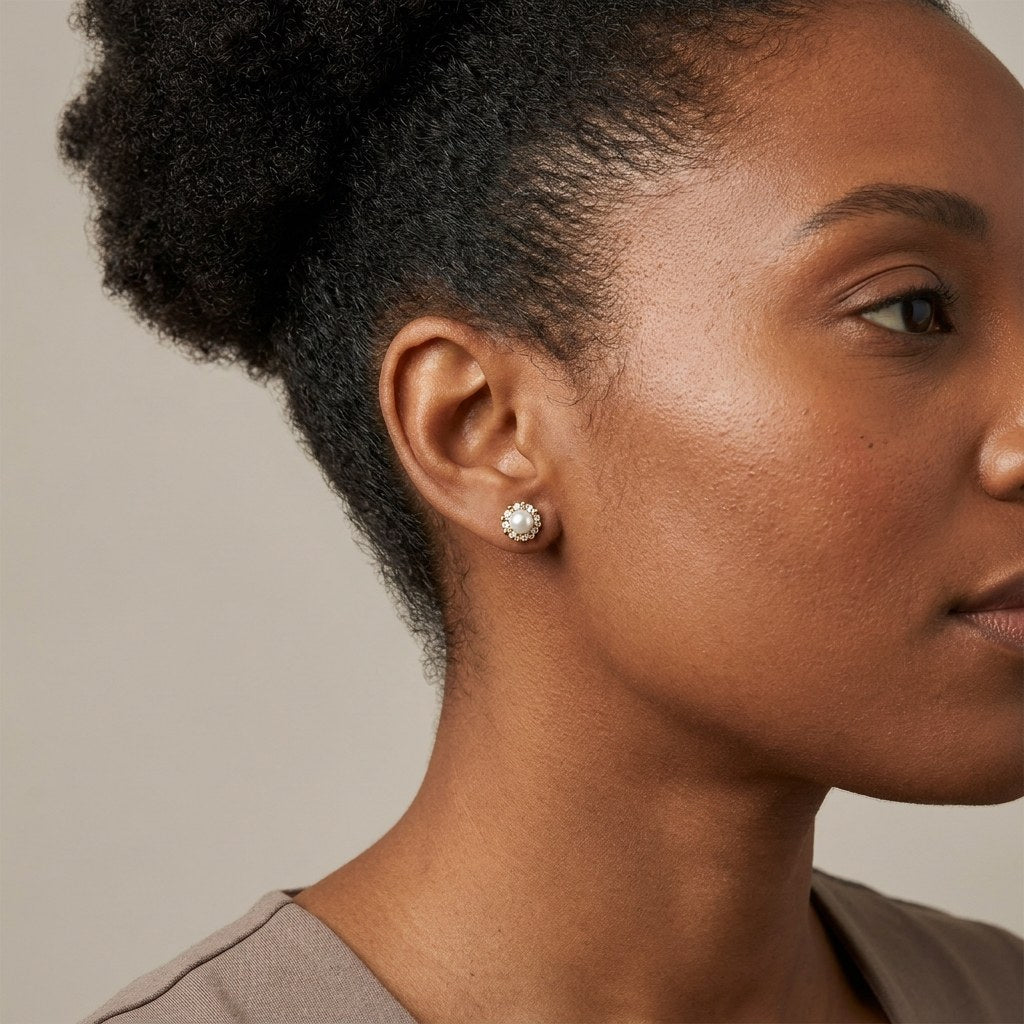 14K solid gold pearl floral halo stud earrings worn on an ear