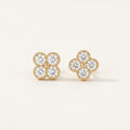 14K solid gold four leaf clover stud earrings on a warm ivory background