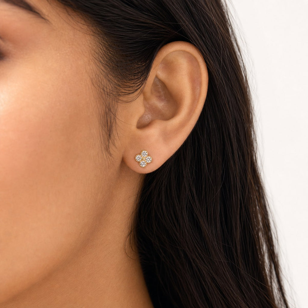 14K solid gold four leaf clover stud earrings worn on an ear