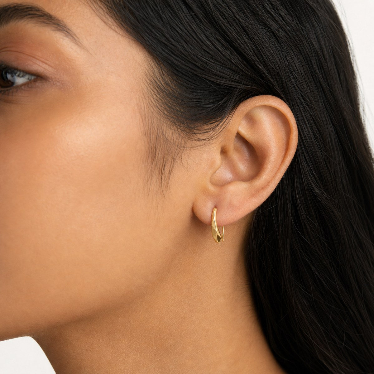 14K solid gold faceted threader stud earrings worn on an ear