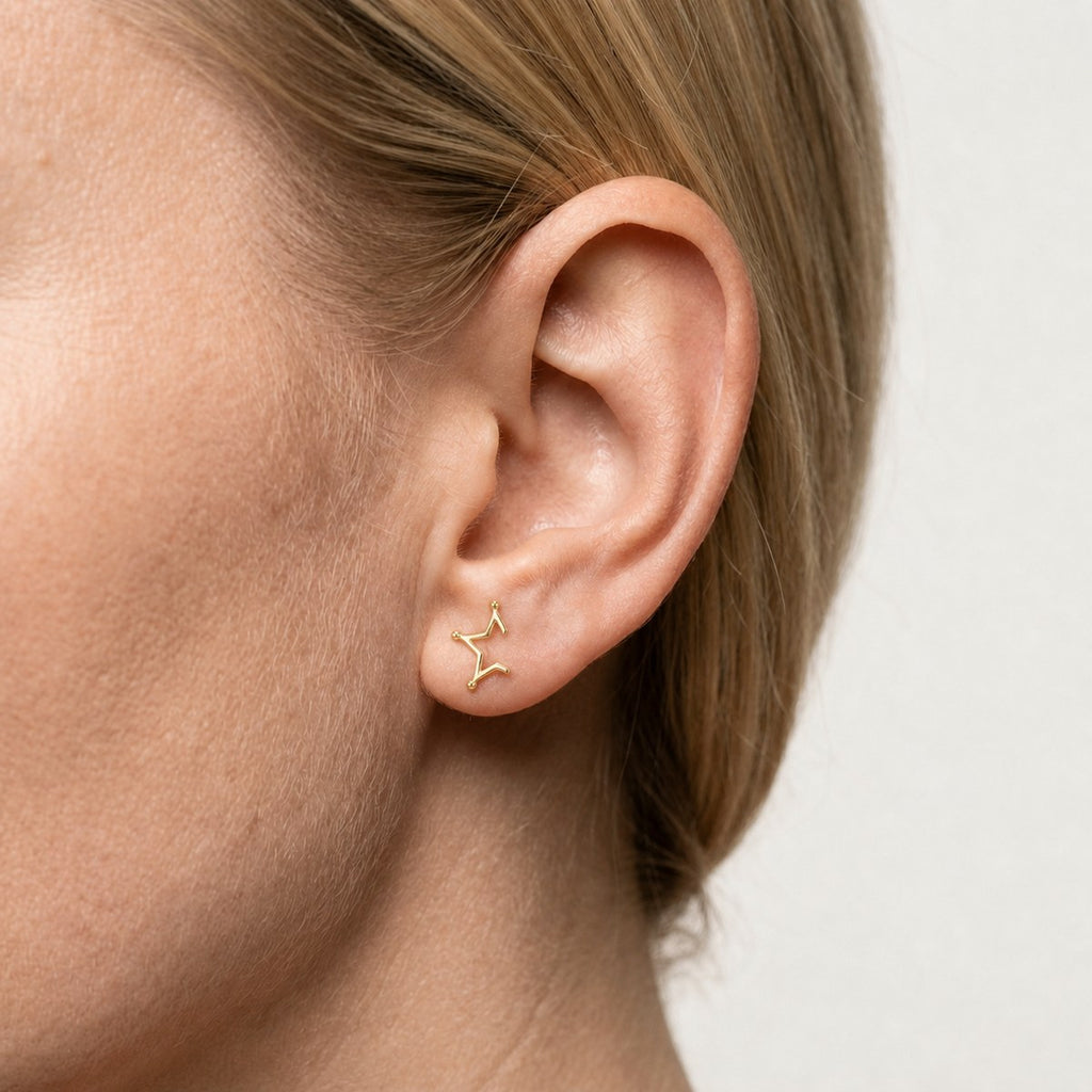 14K solid gold minimal constellation stud earrings worn on an ear